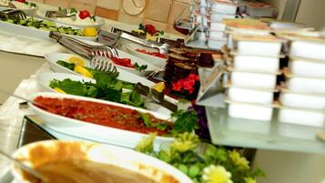 Um buffet com diversos alimentos e utensílios.
