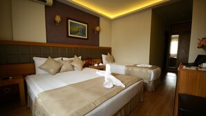 A hotel room with two beds, a desk, and a chair. - Anzac Hotel (Çanakkale)