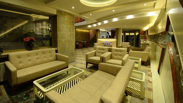 A spacious lobby with a large sofa, armchairs, and a coffee table. A reception desk is visible in the background. - Anzac Hotel (Çanakkale)