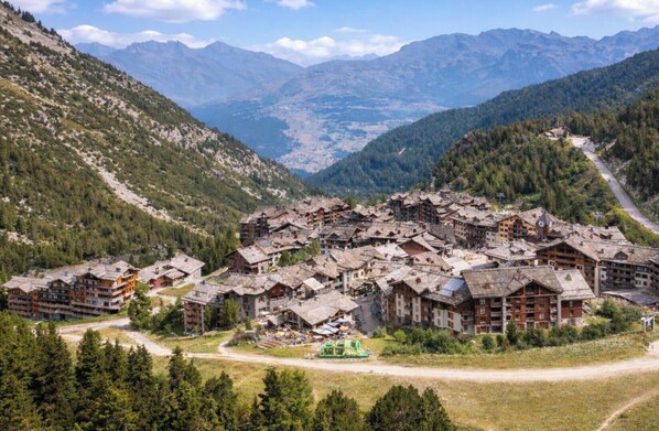 A mountainous village with traditional wooden buildings, a ski lift, and a valley view. - Pierre & Vacances Premium Arc 1950 Le Village (Bourg-Saint-Maurice)
