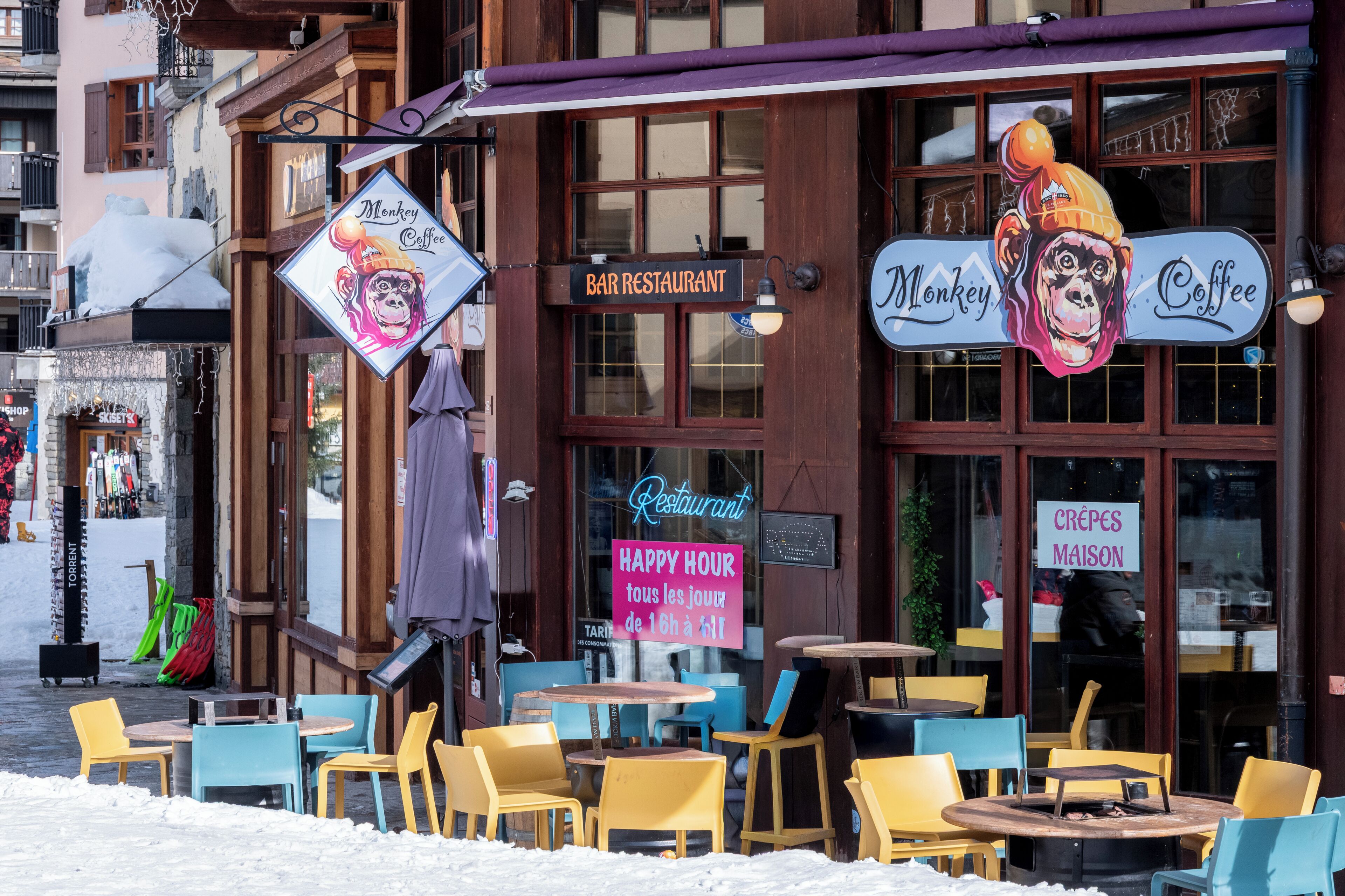 A bar restaurant with outdoor seating and a monkey-themed sign.