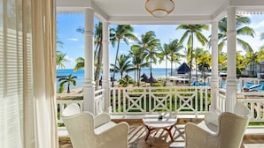 A covered outdoor seating area with a view of the beach and ocean.