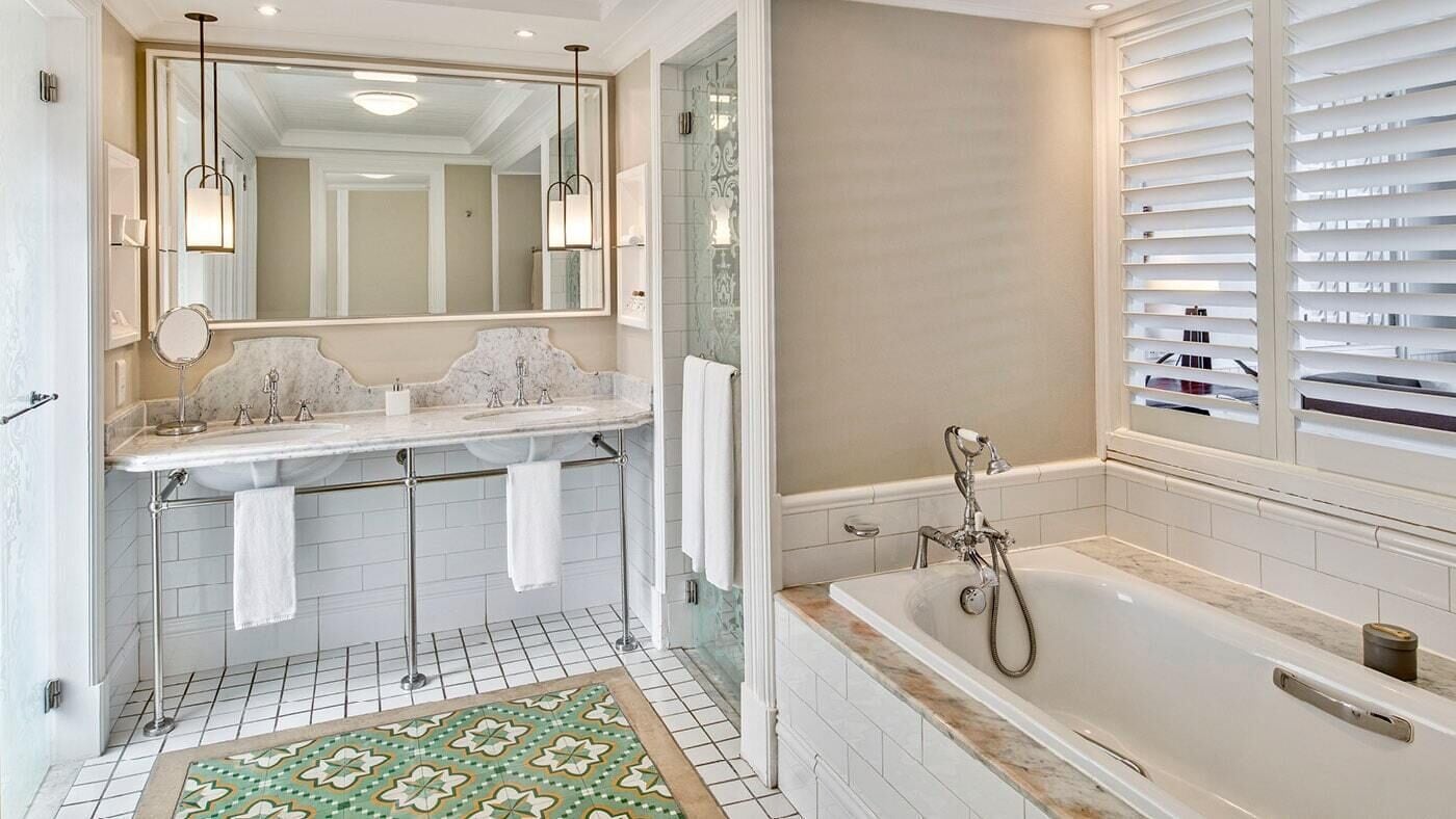 A bathroom with a large mirror, a bathtub, and a shower.