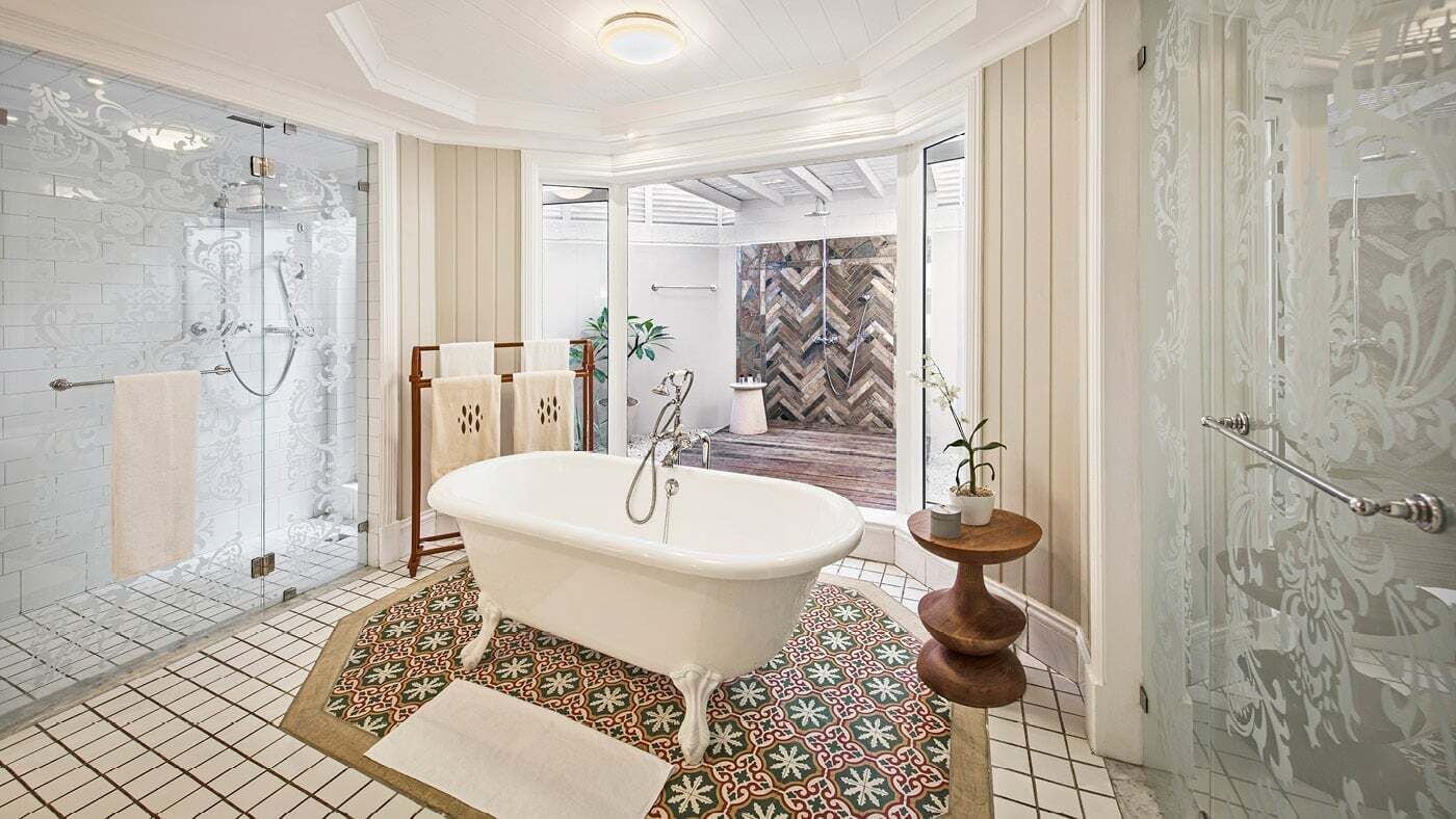 Un bagno con una vasca freestanding, una cabina doccia in vetro e piastrelle a motivi.