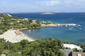 A coastal area with a beach, boats, and a marina. - Bagaglino I Giardini di Porto Cervo (Arzachena)
