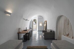 A modern, minimalist room with a dining area, a sofa, and a bed.
