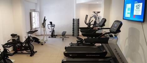 A gym with treadmills, stationary bikes, and various exercise equipment.