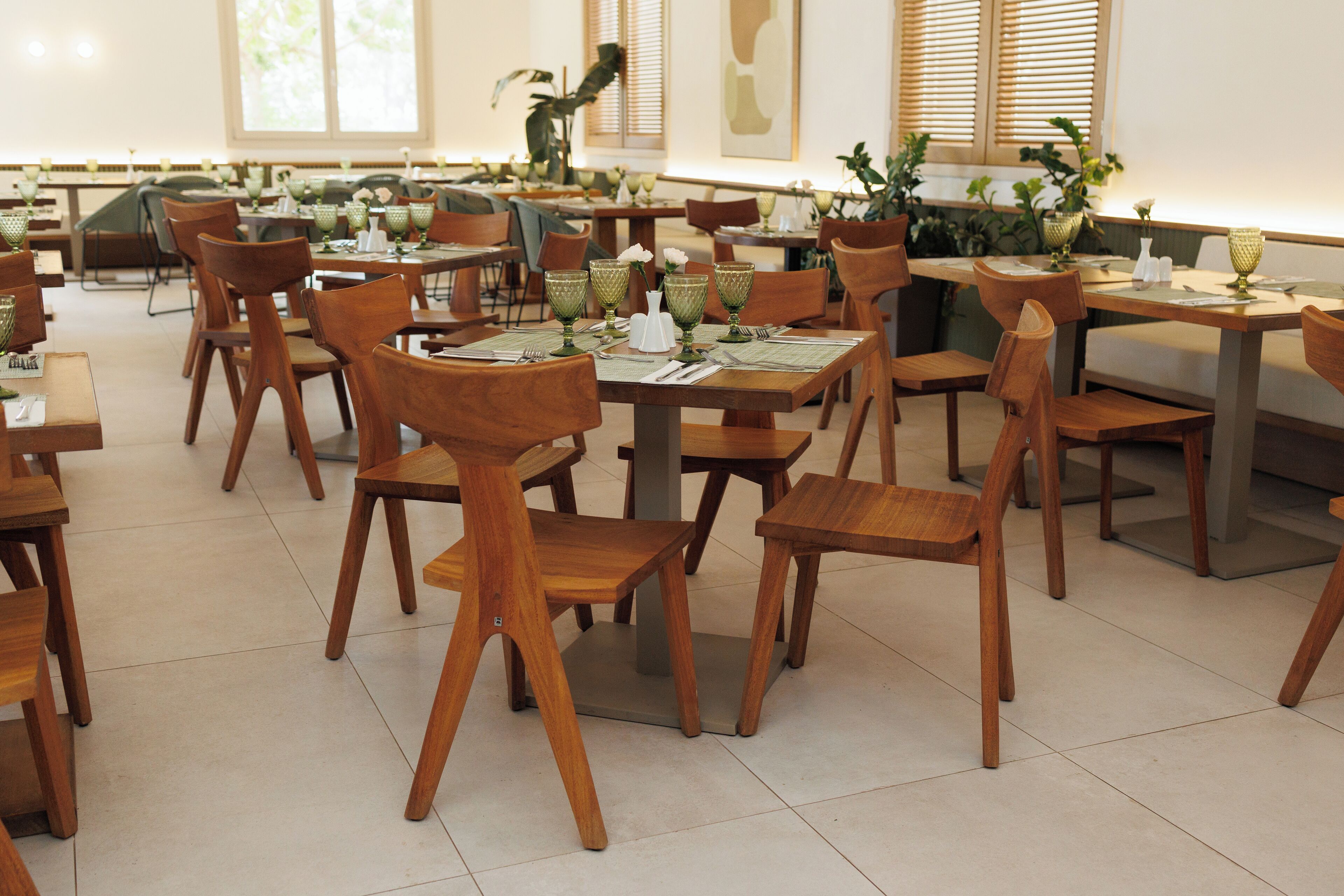 A spacious dining area with multiple wooden tables and chairs, arranged in a clean and organized manner.