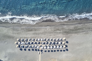 On the beach, sun loungers, beach umbrellas, beach towels - Santo Miramare Resort (Santorini)