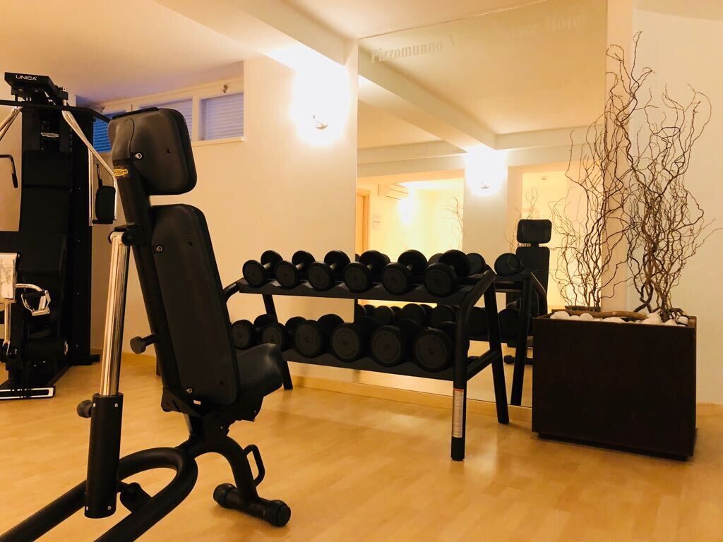 Ein Fitnessraum mit Trainingsgeräten, einer Bank und einer Hantelbank.