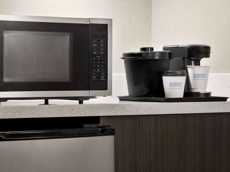 Eine Küche mit Mikrowelle, Kaffeemaschine und Kaffeekanne.