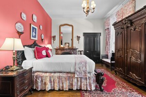 Un dormitorio con una cama grande, cómoda, espejo y alfombra roja.