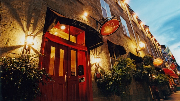 Un edificio histórico con una puerta roja y un letrero que dice "Le Clos Saint Laurent".