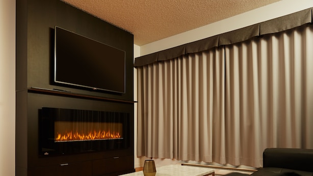 A modern living room with a flat-screen TV mounted above a fireplace, a sofa, and a coffee table. - Hôtel Le Dauphin Montréal - Longueuil (Longueuil)