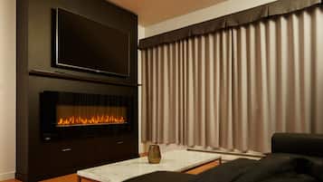 Suite Deluxe, 1 cama de matrimonio grande | Zona de estar | Televisión de pantalla plana de 55 pulgadas con canales por cable