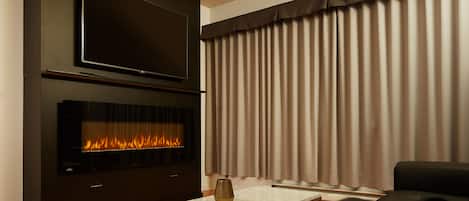 Suite Deluxe, 1 cama King size | Área de sala de estar | Televisión de pantalla plana de 55 pulgadas con canales por cable