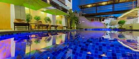 Una piscina al aire libre, sombrillas, tumbonas