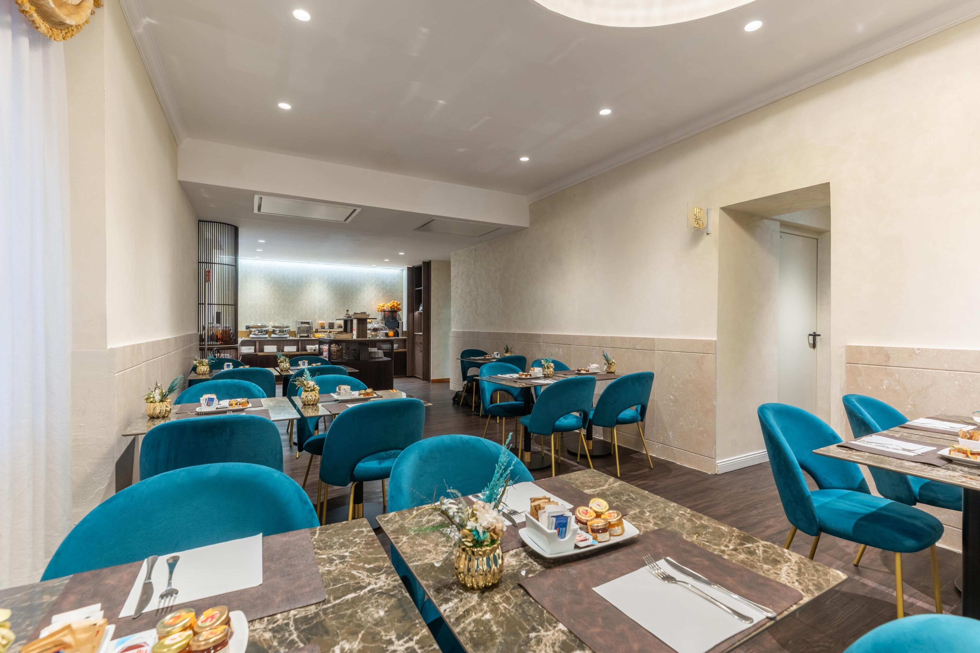 A restaurant with blue chairs, marble tables, and a buffet area in the background.