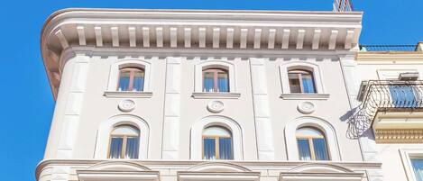 A multi-story building with a classical architectural style, featuring ornate balconies and a symmetrical facade.