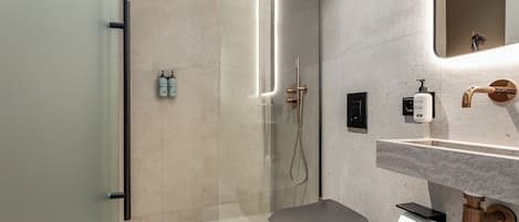 Une salle de bain moderne avec une douche à parois de verre, des toilettes et un lavabo avec un miroir.
