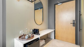 Um banheiro moderno com bancada de mármore, porta de madeira e espelho.