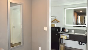 A bathroom with a mirror, sink, and a black cabinet. - Hotel Milagro (Chula Vista)