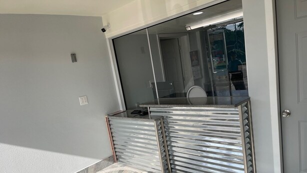 Un baño moderno con cabina de ducha de vidrio, suelo de baldosas y puerta blanca.
