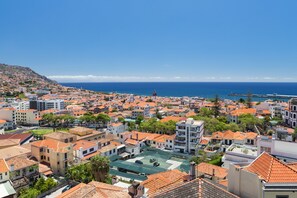 A coastal cityscape with a mix of residential buildings and a prominent church spire. - Hotel Monte Carlo (Funchal)