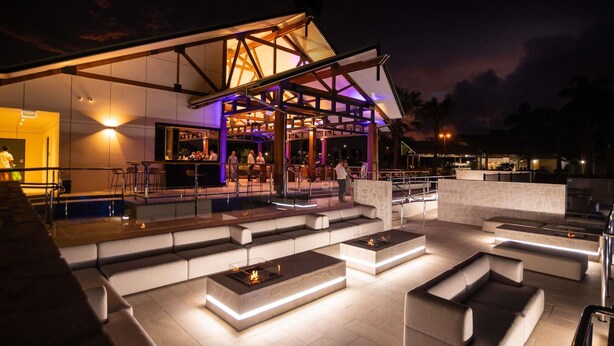 An outdoor seating area with modern furniture and a bar. - Mercure Darwin Airport Resort (Eaton)
