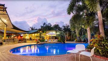 Relax by the resort's pool surrounded by lush tropical vegetation and comfortable lounge seating.