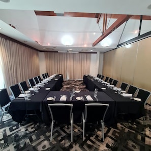 A conference room with a long table set for a meeting, surrounded by chairs. - Mercure Darwin Airport Resort (Eaton)