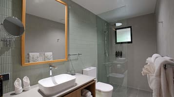 Een moderne badkamer met een grote spiegel, een wastafel, een toilet en een douche met glazen wanden.