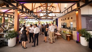 A spacious indoor area with a high ceiling and wooden beams, featuring a seating area with tables and chairs, and potted plants. - Mercure Darwin Airport Resort (Eaton)