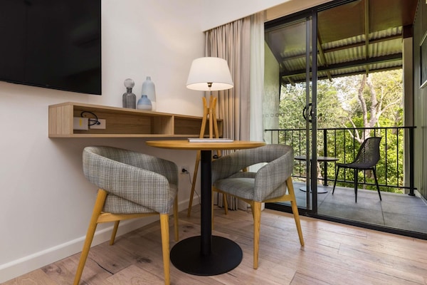 Escritorio, cortinas blackout y tabla de planchar con plancha