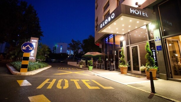 A hotel entrance with a sign reading "GLOBO HOTEL" and a directional arrow sign. - Hotel Globo (Split)