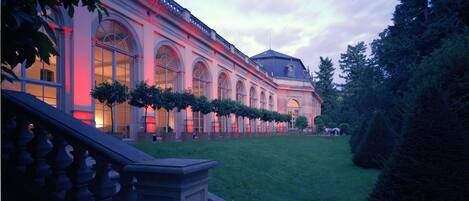 A large building with arched windows and a well-maintained lawn.