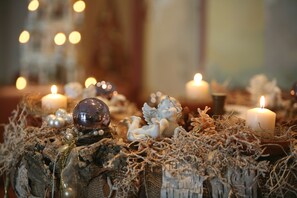 A decorative arrangement with candles, a crystal ball, and angelic figures on a textured surface. - Schloss Hotel Dresden-Pillnitz (Dresden)