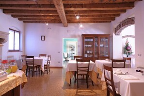 Enjoy a formal dining experience in this beautifully appointed space with a wooden ceiling, elegant tables, and a stylish cabinet.
