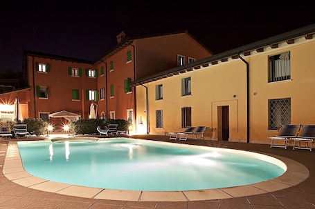 Una piscina al aire libre de temporada, sombrillas