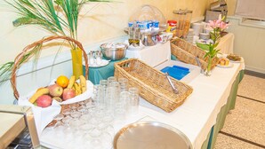 Una mesa de buffet con diferentes alimentos, cristalería y un piano.