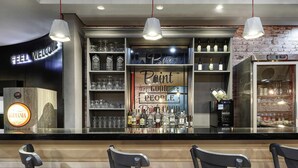 A bar area with a 'Feel Welcome' sign, shelves with liquor bottles, and a 'Point Good People' sign. - ibis Taubate (Taubate)