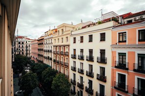 A row of multi-story buildings with balconies, a street below, and trees in the foreground. - ibis Styles Madrid Maravillas (Madrid)