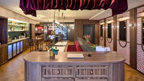 Un área de bar moderna con un letrero de neón que dice "MARAVILLAS", muebles de madera y vistas panorámicas de la ciudad.