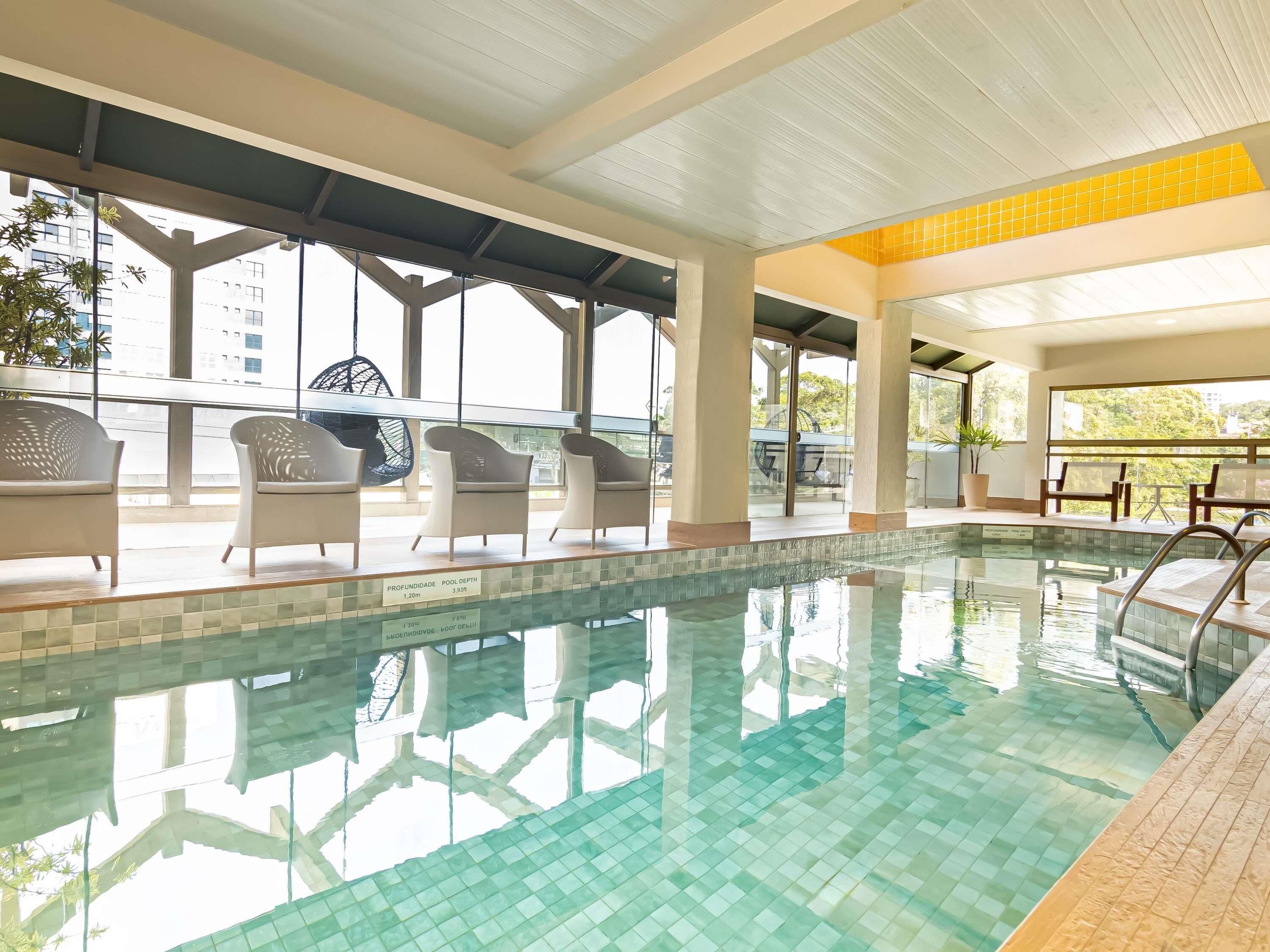 Una piscina techada, sillones reclinables de piscina
