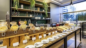 A buffet setup with various food items and labels in a modern setting. - Mercure Florianópolis (Florianópolis)