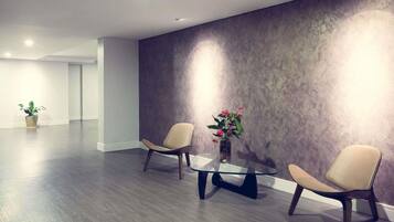 Una habitación moderna con dos sillas, una mesa de vidrio y una planta en maceta.