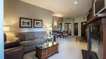 A living room with a sofa, coffee table, and framed pictures on the wall.