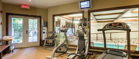 A gym with treadmills, elliptical machines, and free weights.