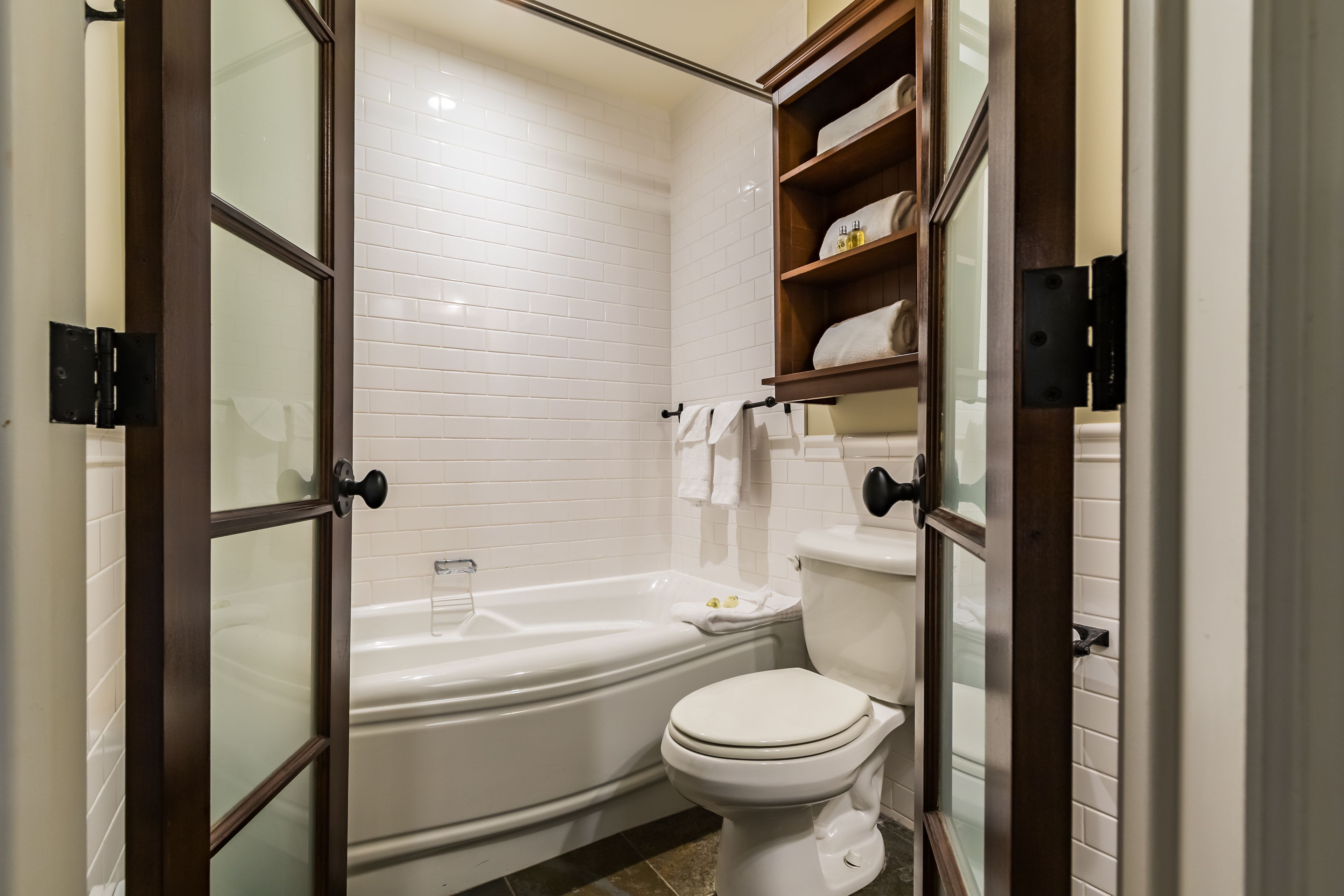 Une salle de bain moderne avec une baignoire blanche, des toilettes et une douche séparée par une paroi de verre.