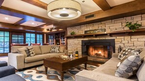 Una sala de estar acogedora con chimenea de piedra, asientos cómodos y ventanas amplias.